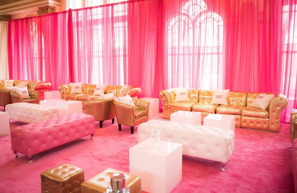 amazingcelebrationsllc.com pink, gold and white lounge area with pink carpets and pink drapery with custom pillows